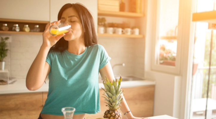 A lady enjoying a glass of orange juice.