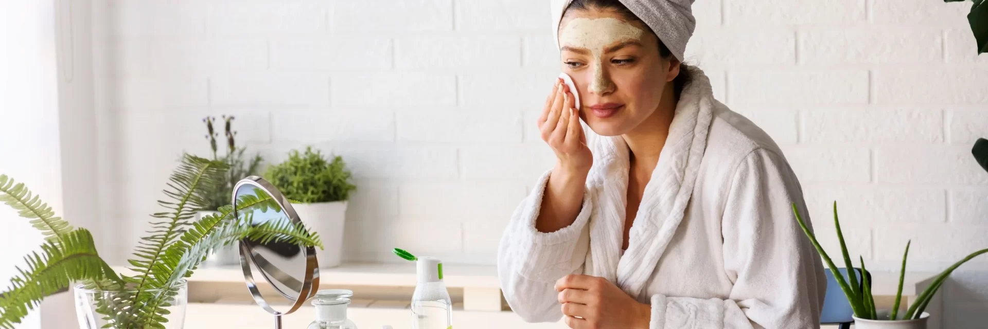 A woman applying skin care product to her face