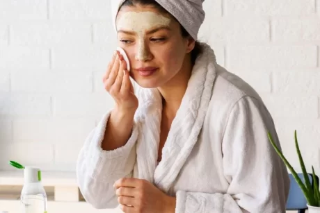 A woman applying skin care product to her face