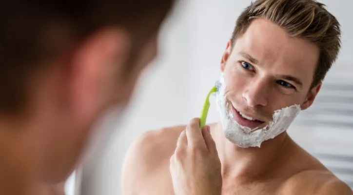 man shaving in front of the mirror