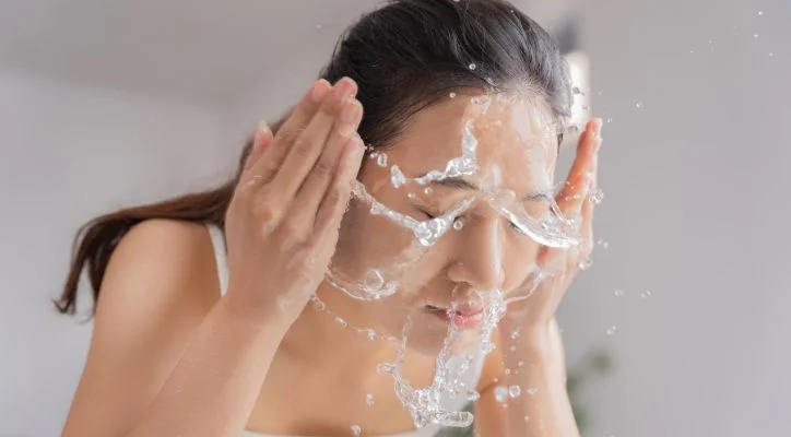 woman washing her face