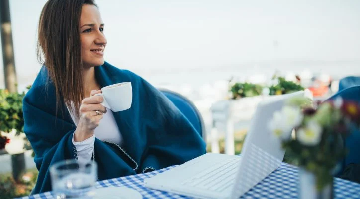 A lady drinking coffee outside