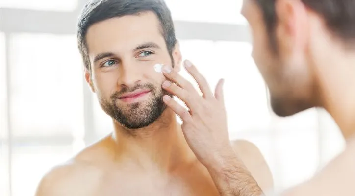 man putting a cream on his face