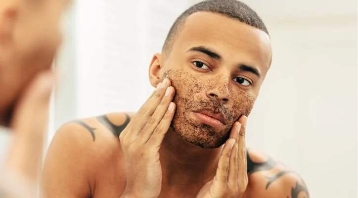man applying skin care product on his face